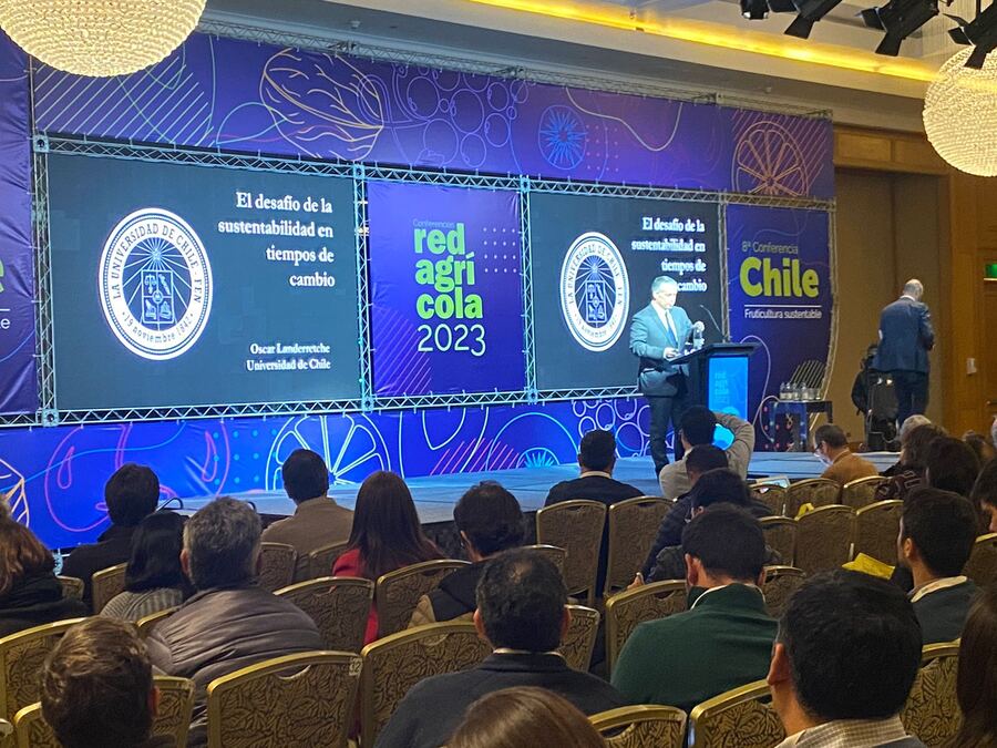 Conferencia con escenario, pantallas y estructura de truss