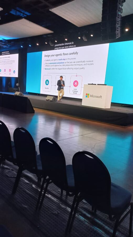 Congreso de tecnología con pantallas gigantes y transcripción proyectada en vivo