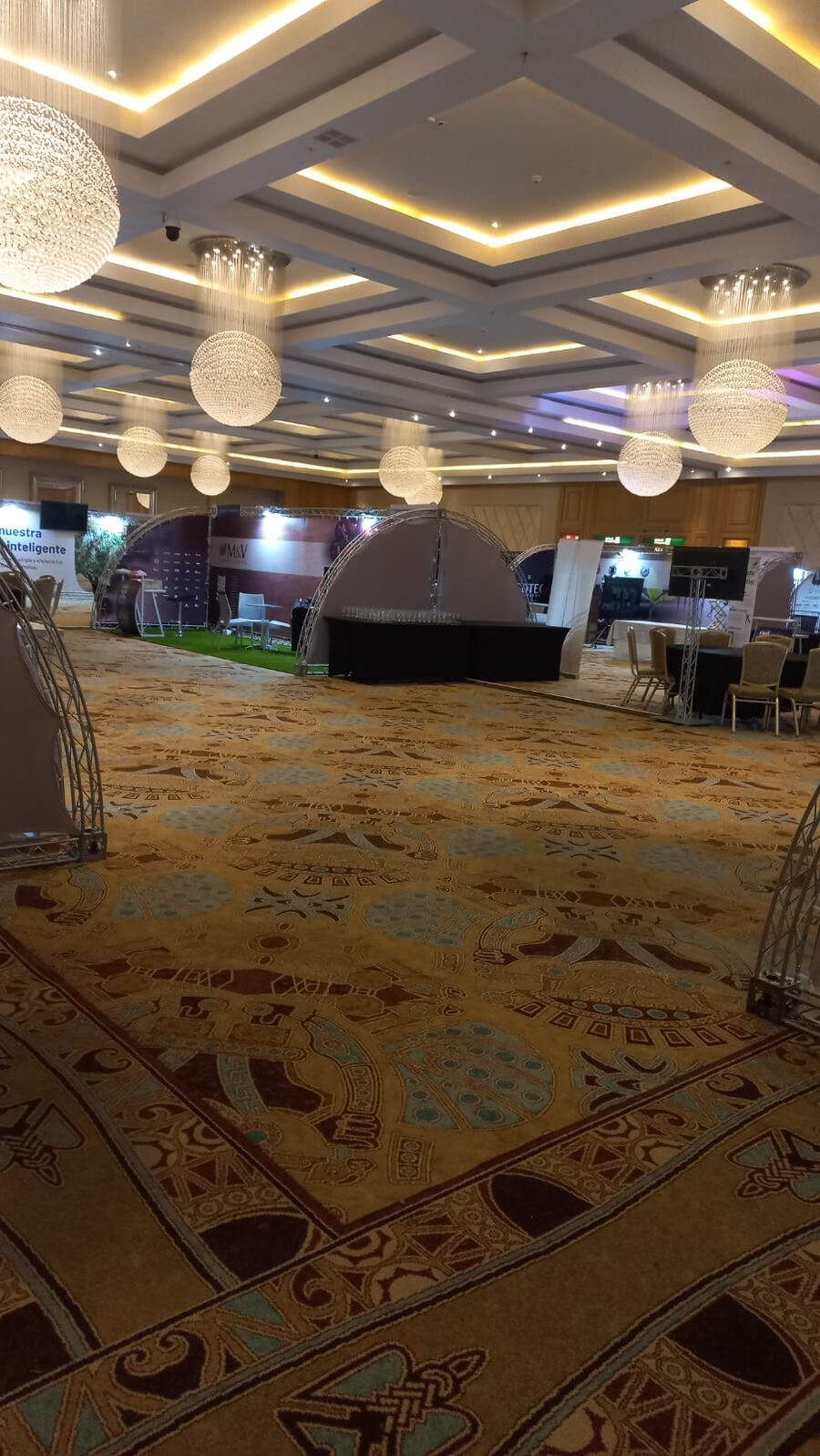 Salón de hotel con los estands montados antes de la apertura de la conferencia